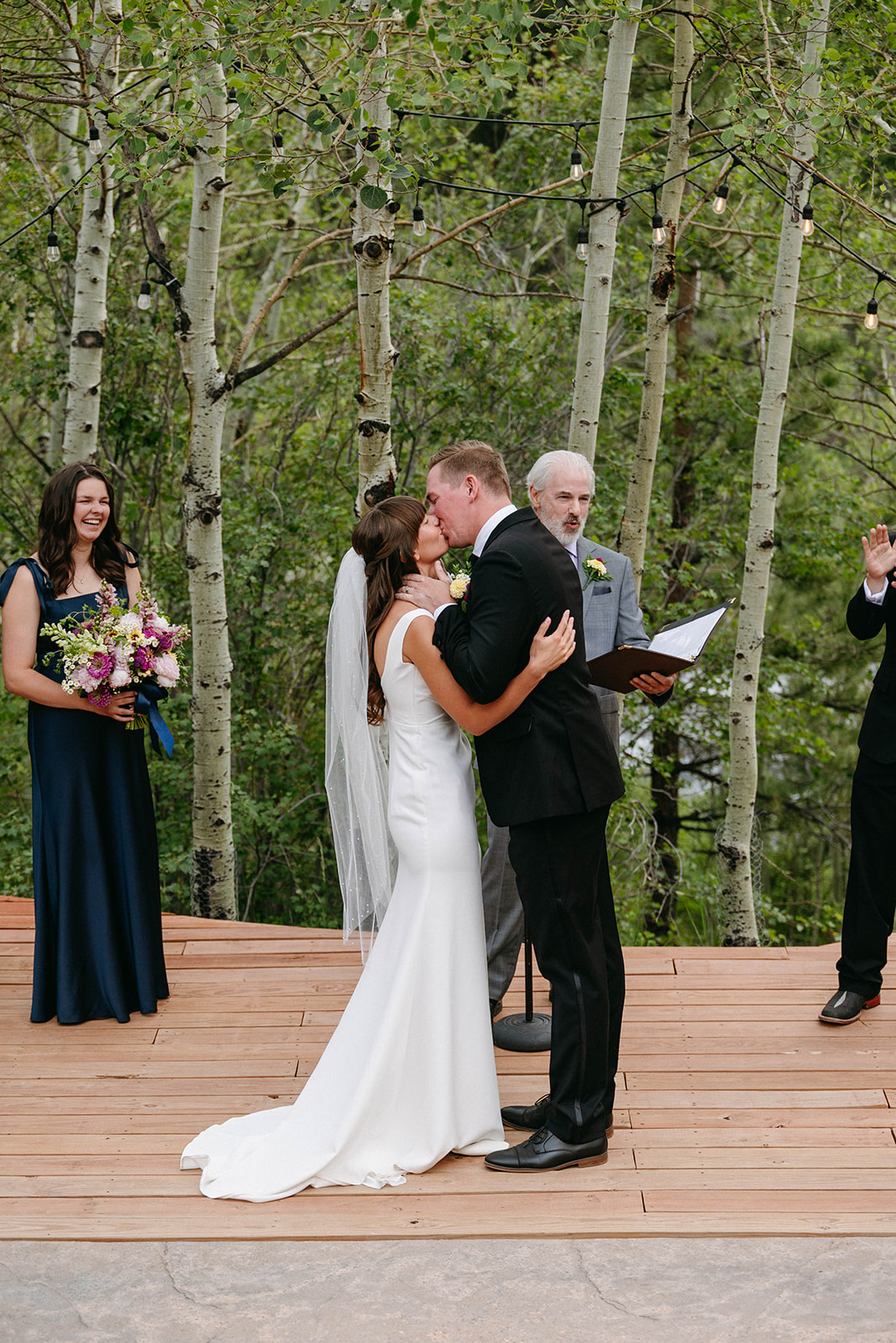 Jason and Amy kissing on the rocks framed by aspen trees